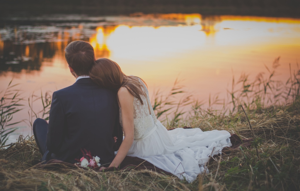 Autumn sunset bride and groom sitting by a pond photo by freestocks.org on unsplash